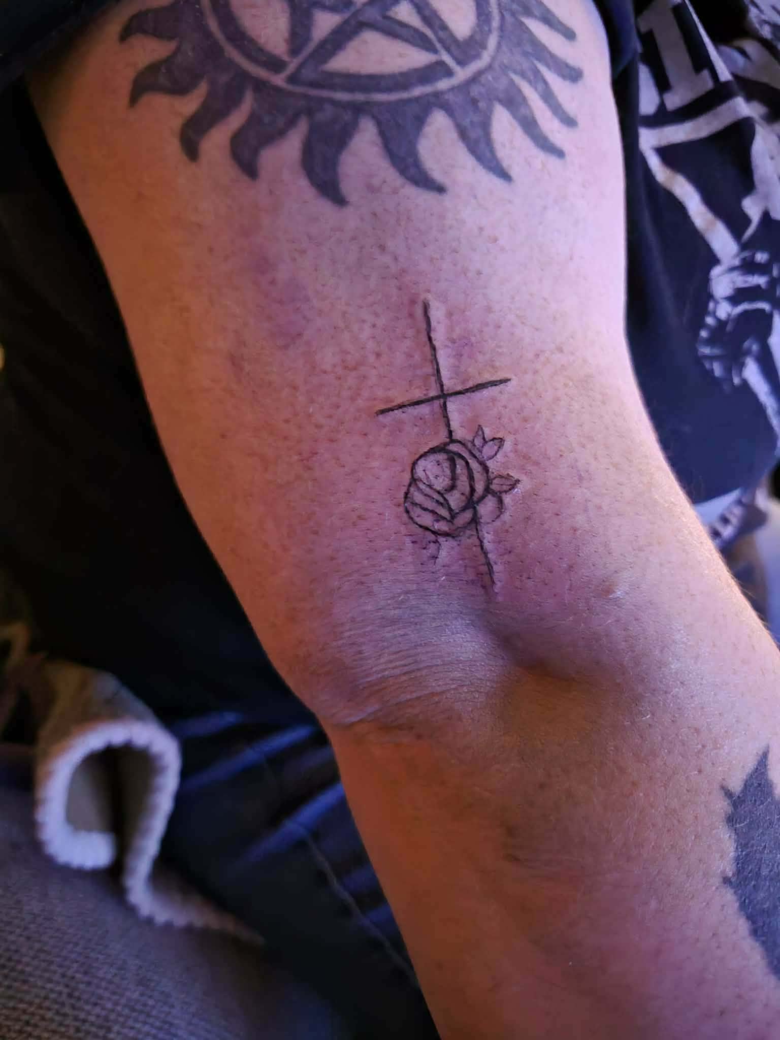 Fine line cross and rose tattoo