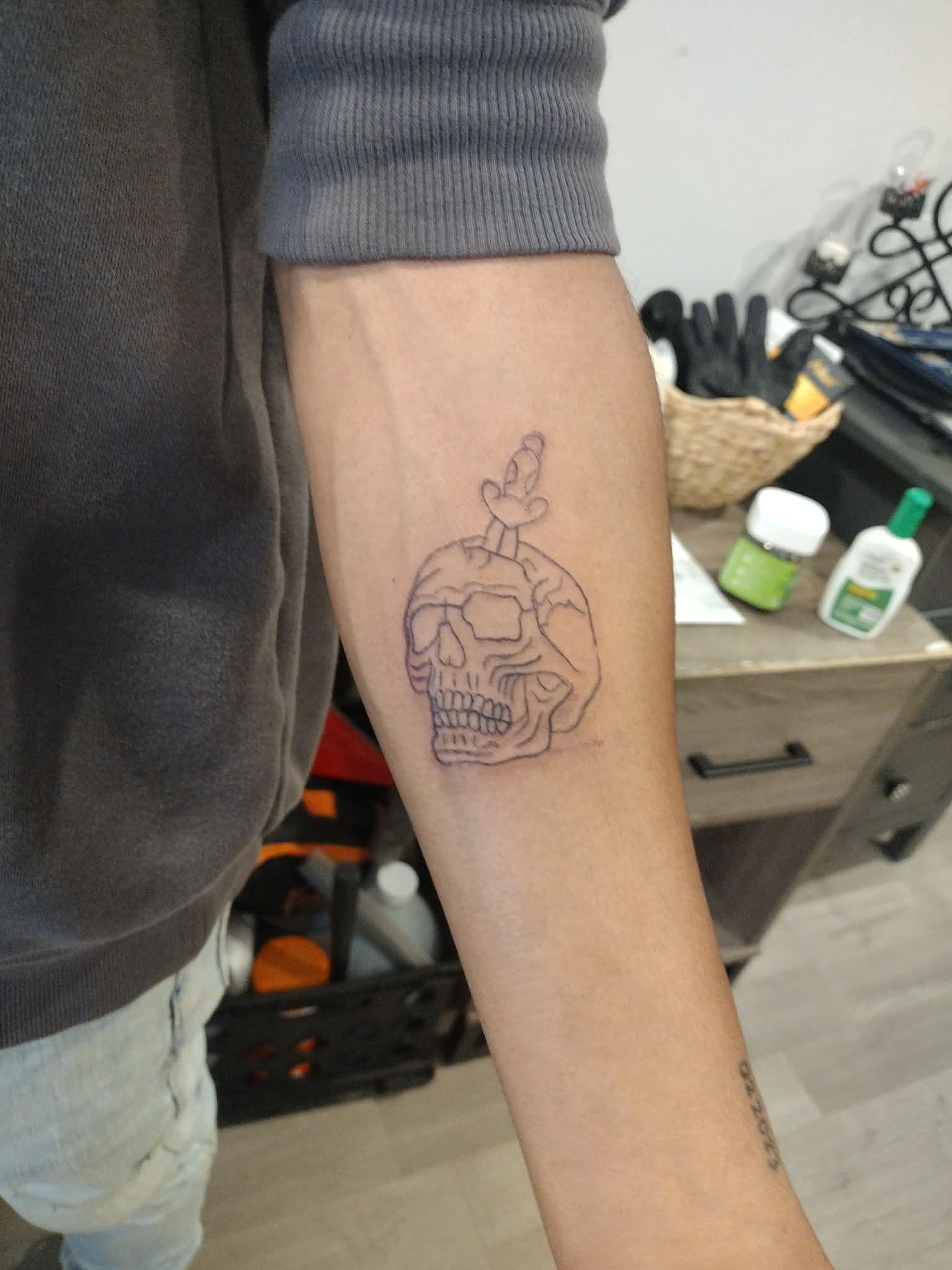 Skull and dagger linework on forearm